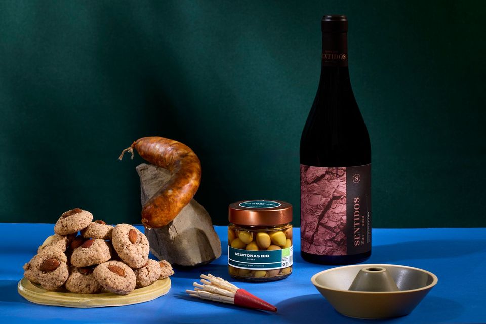 Uma edição de caixa: enchido, azeitonas, vinho, bolachas de amêndoa e uma taça de barro